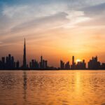 Enchanting view of Dubai's skyscrapers at sunset with the iconic Burj Khalifa outlined against the vivid sky.